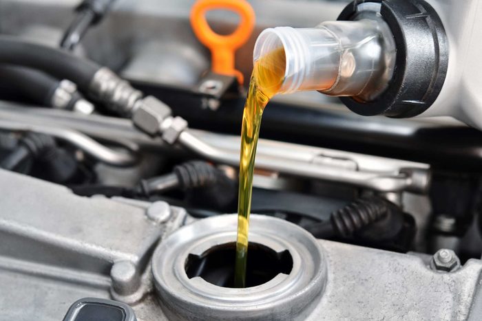 close up of pouring liquid into a car engine