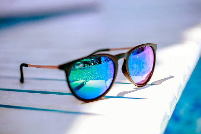 sunglasses on the edge of a pool