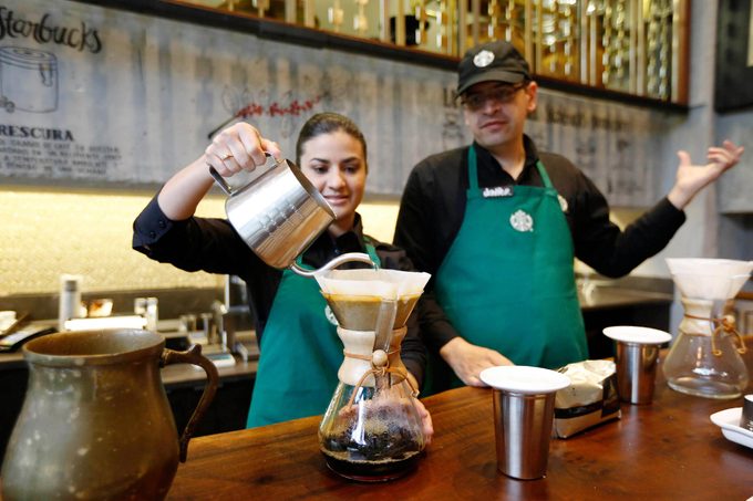 A Starbucks employee demonstrates the preparation of a cup of coffee during a media tour of the new shop in Bogota, Colombia, . The three-floor coffee house in Bogota is the first of 50 that the Seattle-based company plans to open here in the next five years