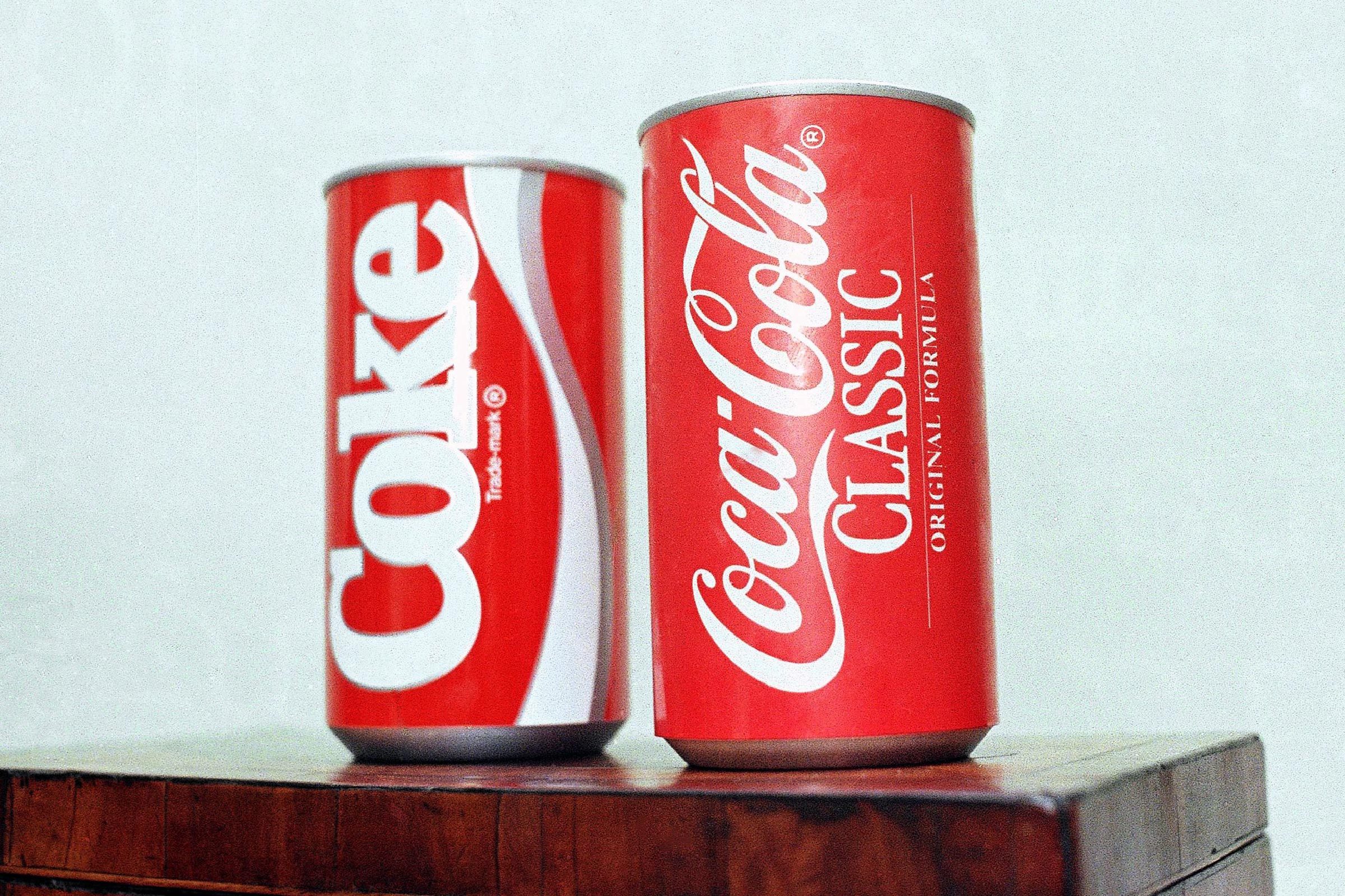 Cans of New Coke and Coca-Cola Classic are on display during a news conference in Atlanta. New Coke's sweeter formula was a marketed as an improved replacement for the flagship soda, but the outcry was immediate and sustained. Coke tried to sell both versions for awhile, but eventually reverted to "Coca-Cola Classic