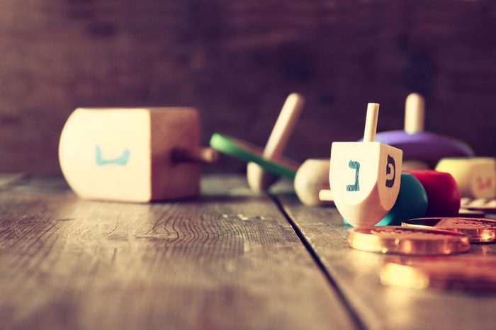 Image of jewish holiday Hanukkah with wooden dreidels colection (spinning top) and chocolate coins on the table