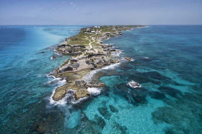 Isla Mujeres, Aerial View Punta Sur. Crystal clear turquoise water, waves crashing on the rocky shore, and the ruins of the temple of Ixchel.