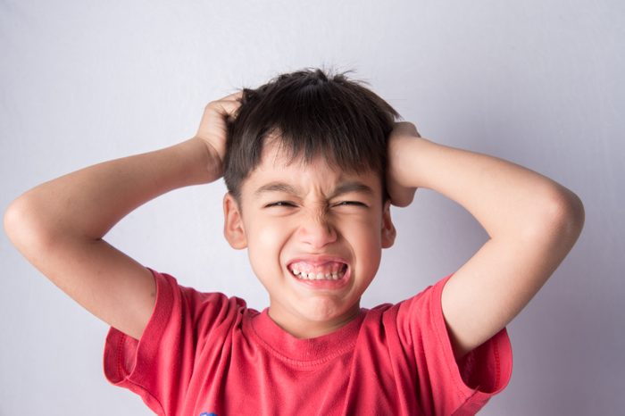 Little boy itchy his head stress face headache