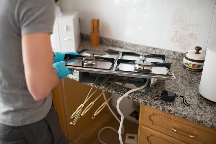 High Angle View Of Man Repairing Gas Stove At Home