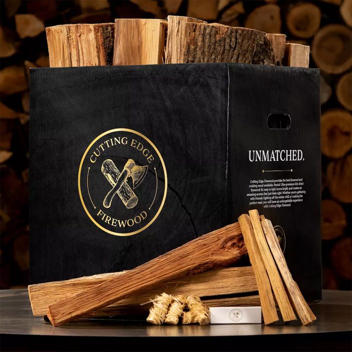 Box displays stacked firewood and kindling on a table; text reads 