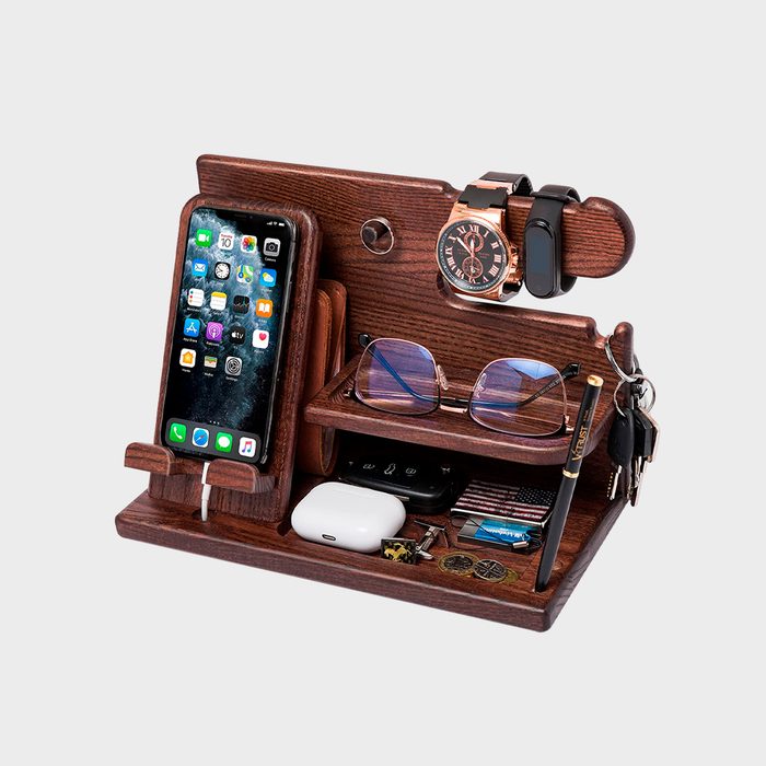 Wooden organizer holds phone, glasses, keys, watch, and pen, displaying items on various shelves in a neat arrangement against a plain background.