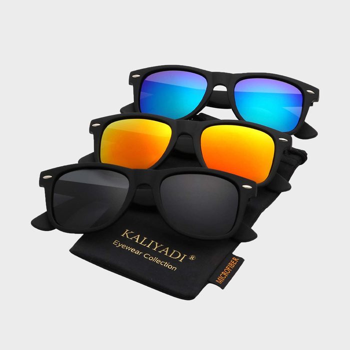 Three pairs of sunglasses rest on a black pouch. Lenses are blue, orange, and black. The pouch reads 