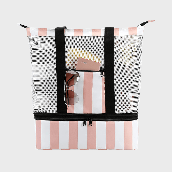 Striped beach bag holds sunglasses and a small notebook labeled 