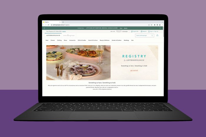 Laptop displays Anthropologie registry webpage featuring dinnerware on a table. Surrounding area shows a purple background. Text: 