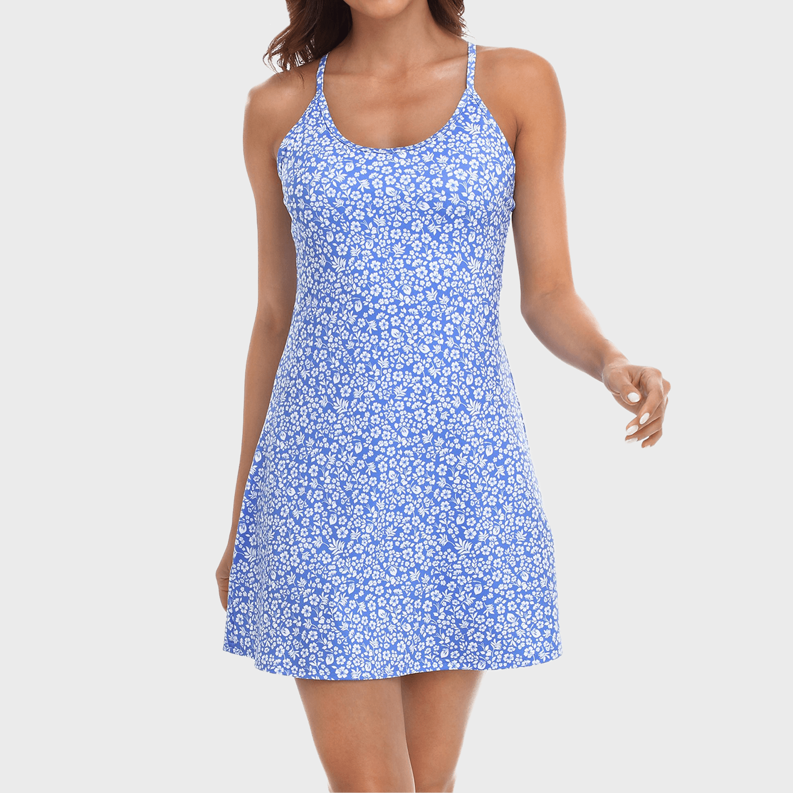A person wears a blue floral dress, standing against a plain white background.