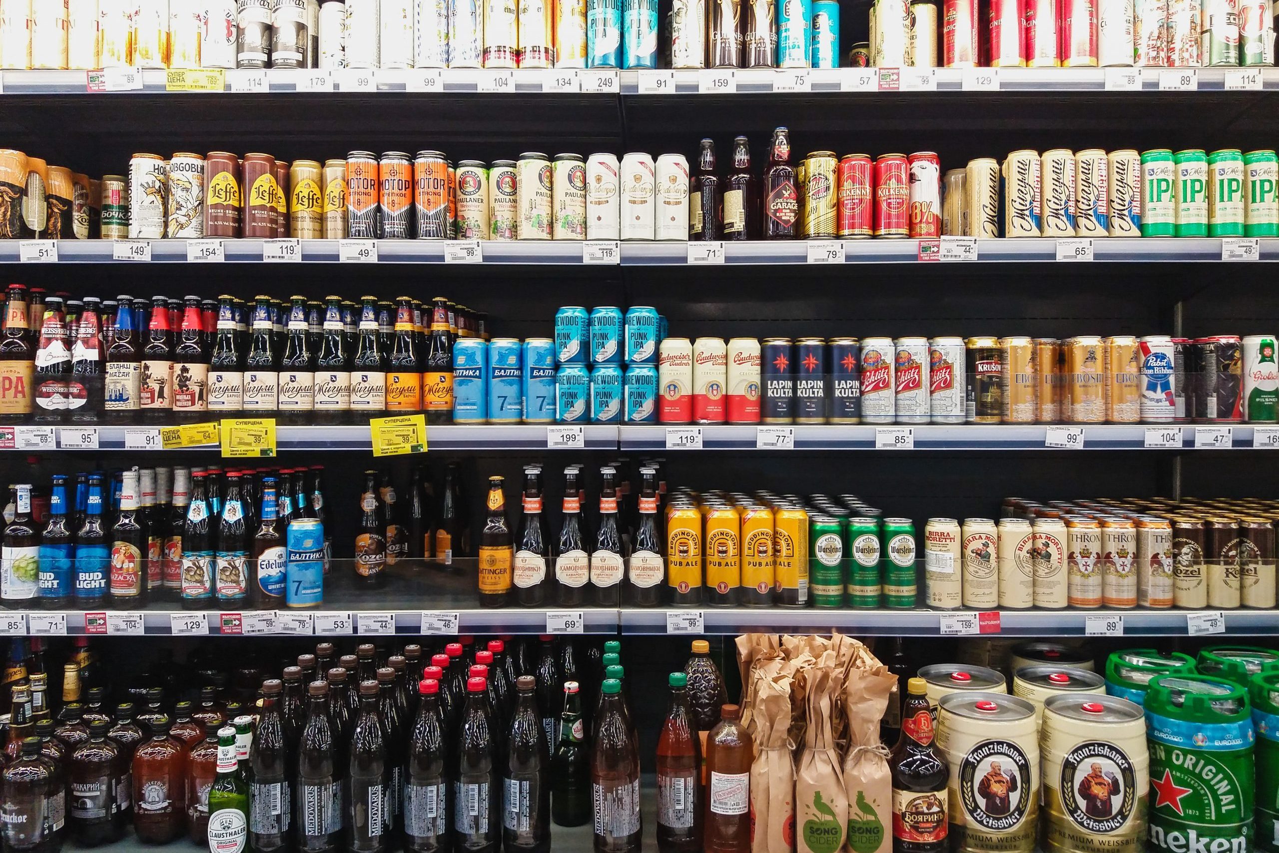 Beer in bottles and cans on grocery store shelves