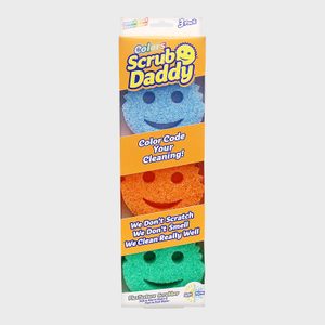 Three colorful, smiley-face scrubbers are stacked vertically in clear packaging, promoting color-coded cleaning with promises of scratch-free, odor-resistant performance.