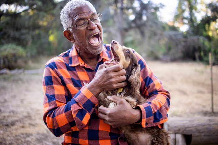 Senior Black Man with Long Haired Dachshund