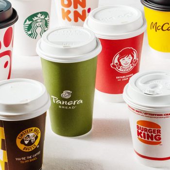 Various branded coffee cups are displayed upright on a white surface, featuring logos like Starbucks, Dunkin', and Burger King, among others.