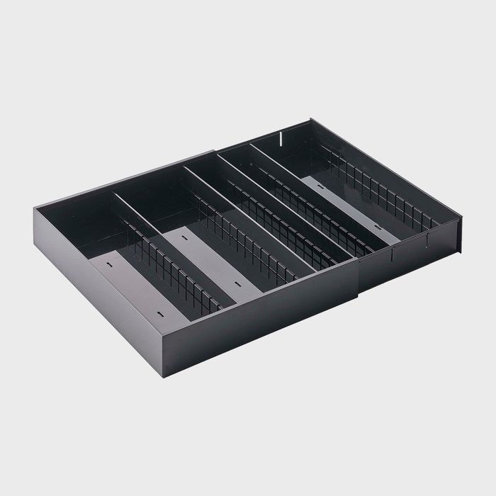 A black metal organizer tray lies empty, featuring adjustable dividers within its compartments, against a plain white background.