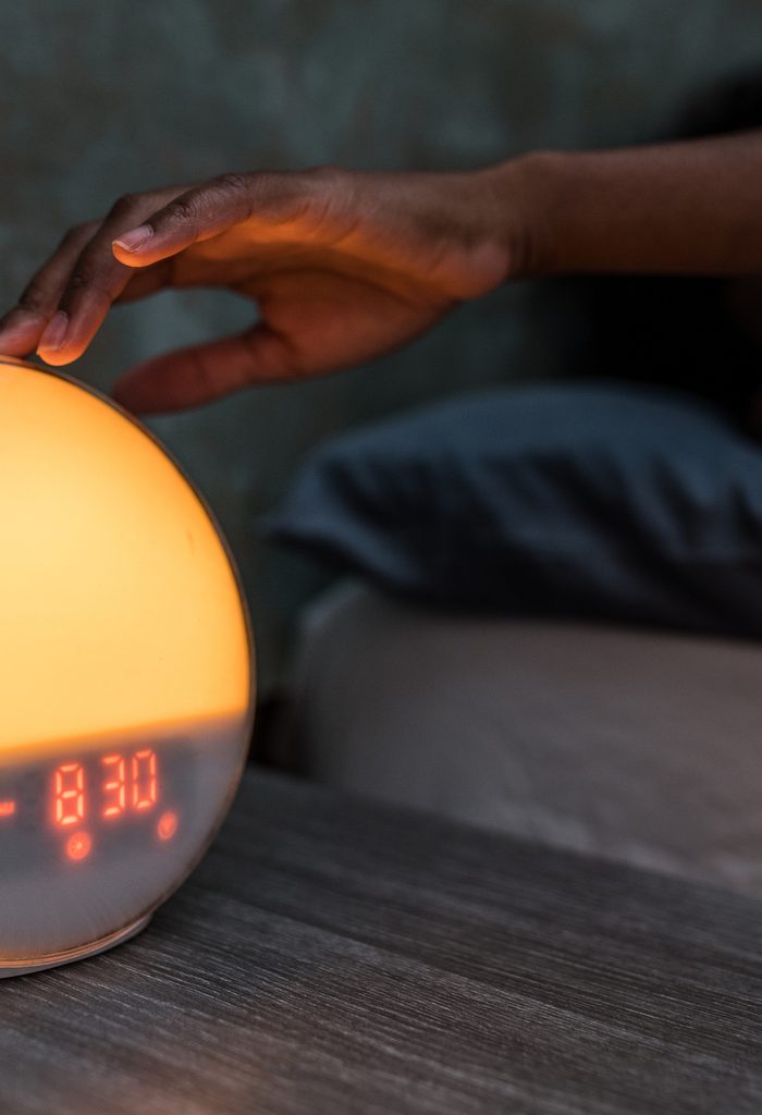 African American woman turning off alarm clock