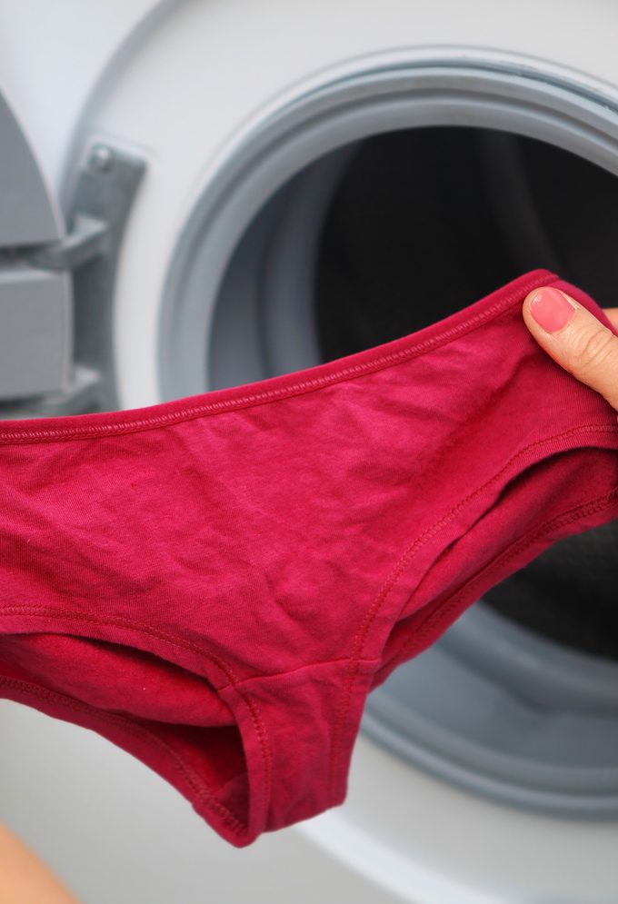 red underwear in hands for laundry