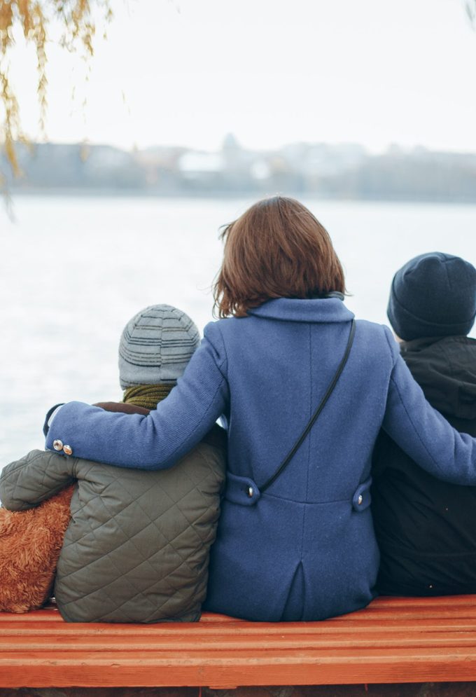 Mother,of,two,boys,sitting,on,a,bench,near,the