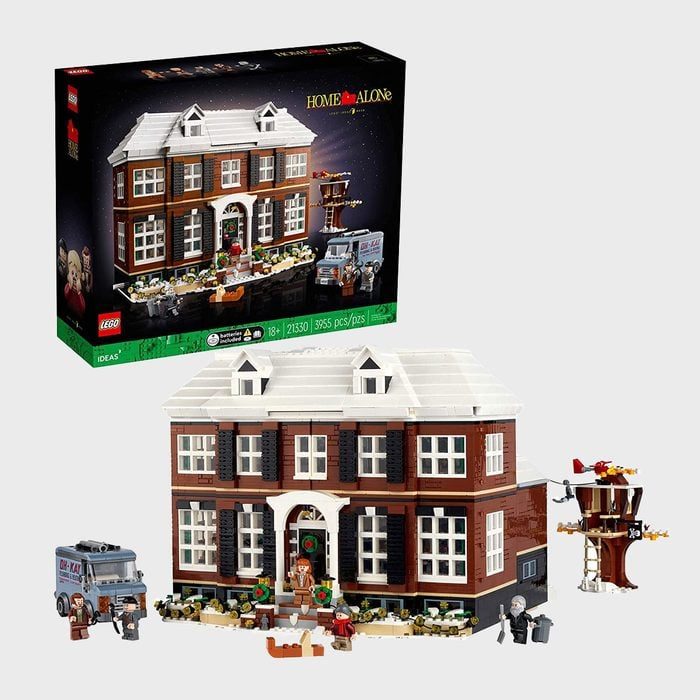 Lego set depicts a large house with winter decorations, characters, and a vehicle, featuring 