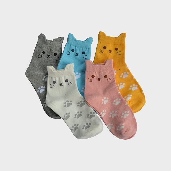 Five colorful socks with cat faces and paw prints lie on a white surface, arranged in overlapping rows.