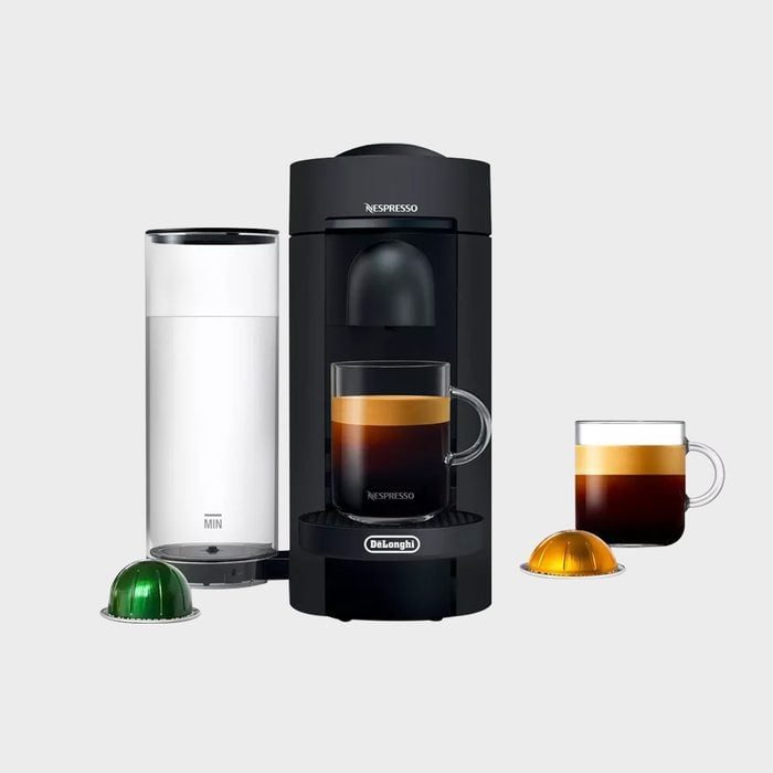 Coffee machine brews espresso; two clear cups with layered coffee nearby; green and orange pods on white background. Text: 