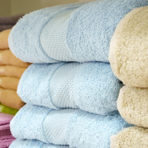 Pastel blue and green Folded bath towels with a woven strip in each one