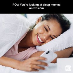 A woman laughing while using her phone in bed with a text that suggests she is looking at memes from RD.Com